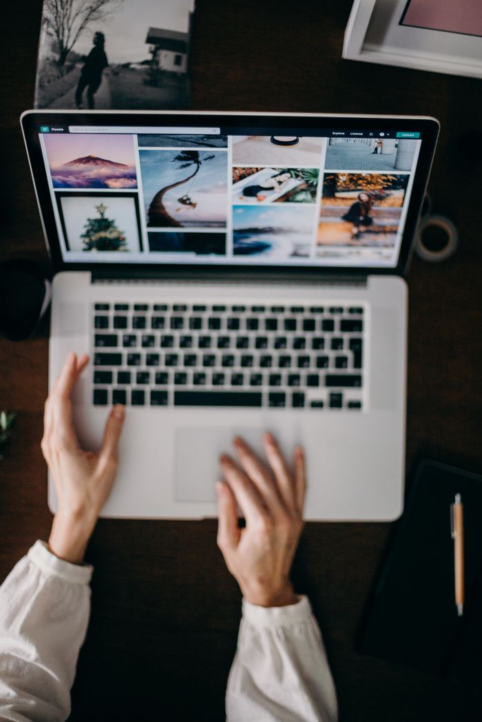 Services Hands using a laptop to browse photo galleries, illustrating digital creativity and remote work.