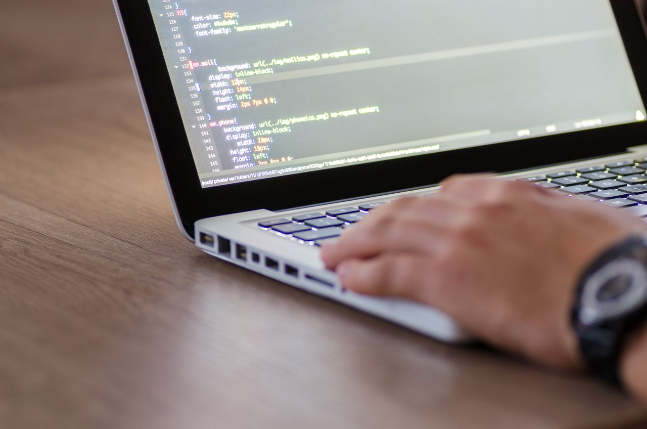 Crafting Captivating Headlines: Your awesome post title goes here Person coding on a laptop with HTML code on screen, showcasing development work.